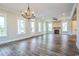 Bright living room boasts wood floors, fireplace, stylish chandelier, and large windows at 8053 Laurel Ash Ave., Myrtle Beach, SC 29572