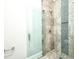 Elegant shower with glass door, stone tile, and a decorative mosaic tile accent at 8053 Laurel Ash Ave., Myrtle Beach, SC 29572