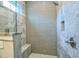 Updated shower features grey-blue tiles, modern fixtures, seating, and a glass door at 8053 Laurel Ash Ave., Myrtle Beach, SC 29572