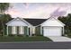 Charming single-story home boasts a welcoming front yard, attached two-car garage and a delightful green color scheme at 85 Northbrook Dr, Murrells Inlet, SC 29576
