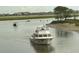 View of boats sailing through the channel, near homes and lush wetlands at 85 Northbrook Dr, Murrells Inlet, SC 29576