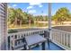 Back porch with table and chairs overlooks tranquil pond with surrounding trees at 881 Palmetto Trail # 103, Myrtle Beach, SC 29577