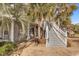 Charming exterior view featuring a staircase, palm trees, and patterned pavers at 881 Palmetto Trail # 103, Myrtle Beach, SC 29577