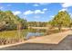 A serene pond is surrounded by mature trees and a grassy bank at 881 Palmetto Trail # 103, Myrtle Beach, SC 29577