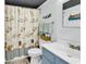 Charming bathroom featuring seashell-themed decor, a shower with curtain, toilet, and a vanity with storage at 912 N Waccamaw Dr. # 1404, Garden City Beach, SC 29576