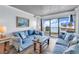 Cozy living room featuring comfortable sofas, rustic wooden coffee table, and a sliding door leading to the balcony with a view at 912 N Waccamaw Dr. # 1404, Garden City Beach, SC 29576