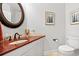 Bathroom with granite countertops, white cabinets, decorative mirror, and an included toilet at 9547 Edgerton Dr. # 301, Myrtle Beach, SC 29572