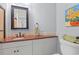 Bathroom with granite countertops, neutral tile backsplash, white cabinets, and colorful art at 9547 Edgerton Dr. # 301, Myrtle Beach, SC 29572