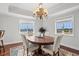 A dining room with a chandelier, a wooden table, and a view of the water at 9547 Edgerton Dr. # 301, Myrtle Beach, SC 29572