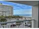 Balcony view overlooking a parking area and palm trees with the building and the ocean in the background at 9820 Queensway Blvd. # 303, Myrtle Beach, SC 29572