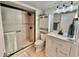 This bathroom features tiled walk-in shower, white vanity with marble countertop, and modern lighting at 9820 Queensway Blvd. # 303, Myrtle Beach, SC 29572