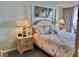 Cozy bedroom featuring a four-poster bed, matching nightstands, and a view of the balcony at 9820 Queensway Blvd. # 303, Myrtle Beach, SC 29572