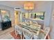 Bright dining area featuring a glass table with seating for six, complemented by a view into the kitchen at 9820 Queensway Blvd. # 303, Myrtle Beach, SC 29572