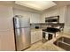 Charming kitchen features stainless steel appliances, granite countertops, and white cabinetry, maximizing storage space at 9820 Queensway Blvd. # 303, Myrtle Beach, SC 29572