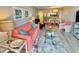 Cozy living room with a vibrant coral sofa, stylish decor, and an open view into the dining area at 9820 Queensway Blvd. # 303, Myrtle Beach, SC 29572