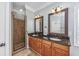 Bathroom featuring double sinks with granite countertops and a tiled walk-in shower at 102-A N Poplar Dr., Surfside Beach, SC 29575