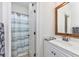 Bathroom with a vanity, mirror, and a toilet and shower area with a blue striped shower curtain at 102-A N Poplar Dr., Surfside Beach, SC 29575