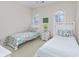 Bright bedroom featuring twin beds, arched windows providing natural light, and beach themed decor at 102-A N Poplar Dr., Surfside Beach, SC 29575