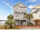 Inviting three-story beach home featuring a charming coastal design and well-manicured landscaping at 102-A N Poplar Dr., Surfside Beach, SC 29575
