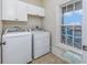 Practical laundry room with a washer, dryer, cabinets, and a window for ventilation and natural light at 102-A N Poplar Dr., Surfside Beach, SC 29575