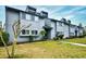 Exterior view of the two-story townhome with gray siding, trimmed shrubs and an expansive lawn at 10301 N Kings Hwy. # 15-8, Myrtle Beach, SC 29572