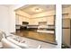 Well lit kitchen with stainless steel refrigerator, white cabinets, and a breakfast bar at 10301 N Kings Hwy. # 15-8, Myrtle Beach, SC 29572