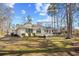 Back exterior view of the home with a deck and manicured lawn at 1043 Yellow Jasmine Dr., Longs, SC 29568