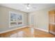 A bright, sunny bedroom features hardwood floors, a ceiling fan, and large windows at 1043 Yellow Jasmine Dr., Longs, SC 29568