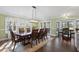 Elegant dining room with a long, dark wood table, cushioned chairs, and abundant natural light at 1043 Yellow Jasmine Dr., Longs, SC 29568