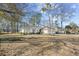 Exterior view of the home showcases its charming facade and manicured lawn in a serene, tree-lined neighborhood at 1043 Yellow Jasmine Dr., Longs, SC 29568