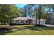 Inviting single-story home featuring a two-car garage, lush landscaping, and a well-maintained lawn at 1043 Yellow Jasmine Dr., Longs, SC 29568