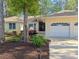 Charming home showcasing manicured landscaping, flowerbeds, and a driveway leading to a two-car garage at 1043 Yellow Jasmine Dr., Longs, SC 29568