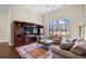 Bright living room featuring hardwood floors, a ceiling fan, and oversized window offering serene backyard views at 1043 Yellow Jasmine Dr., Longs, SC 29568