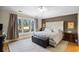 Comfortable main bedroom featuring a large window, wood floors, and a decorative headboard at 1043 Yellow Jasmine Dr., Longs, SC 29568