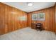 Bedroom with wood paneling and carpet, features a desk and chair by the window at 115 Carolina Ave., Mullins, SC 29574