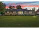 Charming brick home featuring a well-maintained lawn and colorful sunset backdrop at 115 Carolina Ave., Mullins, SC 29574