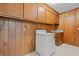 Laundry room with washer, cabinets, and wood paneled walls at 115 Carolina Ave., Mullins, SC 29574