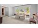 Sunlit living room with neutral tones, comfortable seating, and a picturesque backyard view at 115 Carolina Ave., Mullins, SC 29574