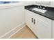 Clean bathroom features a white vanity with black countertop and modern fixtures at 1211-B N Waccamaw Dr., Garden City Beach, SC 29576