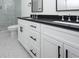 Elegant bathroom features a double vanity with black countertop and tiled shower at 1211-B N Waccamaw Dr., Garden City Beach, SC 29576