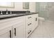 Modern bathroom featuring a double sink vanity with black countertop and white cabinets, complemented by a glass-enclosed shower at 1211-B N Waccamaw Dr., Garden City Beach, SC 29576