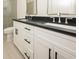 Modern bathroom featuring a double sink vanity with dark countertops, white cabinets, and chrome fixtures at 1211-B N Waccamaw Dr., Garden City Beach, SC 29576