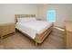 Bright bedroom with a wooden bed frame, matching nightstands, wood flooring, and a window at 1211-B N Waccamaw Dr., Garden City Beach, SC 29576