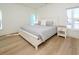 Bright bedroom features a queen-size bed, light hardwood floors and streams of natural light at 1211-B N Waccamaw Dr., Garden City Beach, SC 29576