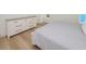 Light-filled bedroom with a dresser, light hardwood floors and view of the bed at 1211-B N Waccamaw Dr., Garden City Beach, SC 29576