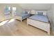 Bright bedroom featuring two twin beds with light wood frames, blue bedding and door to outside porch and ocean views at 1211-B N Waccamaw Dr., Garden City Beach, SC 29576