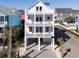 Three story white home with multiple balconies and outdoor living space at 1211-B N Waccamaw Dr., Garden City Beach, SC 29576