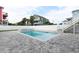 Backyard pool area with a jacuzzi and gray pavers surrounded by a white fence with tropical landscaping and palms at 1211-B N Waccamaw Dr., Garden City Beach, SC 29576