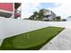 Backyard putting green complemented by an outdoor patio, pool, and privacy fence at 1211-B N Waccamaw Dr., Garden City Beach, SC 29576