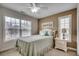 Bright bedroom with neutral walls, a comfortable bed with decorative pillows, and natural light from two windows at 1411 Powhaton Dr., Myrtle Beach, SC 29577